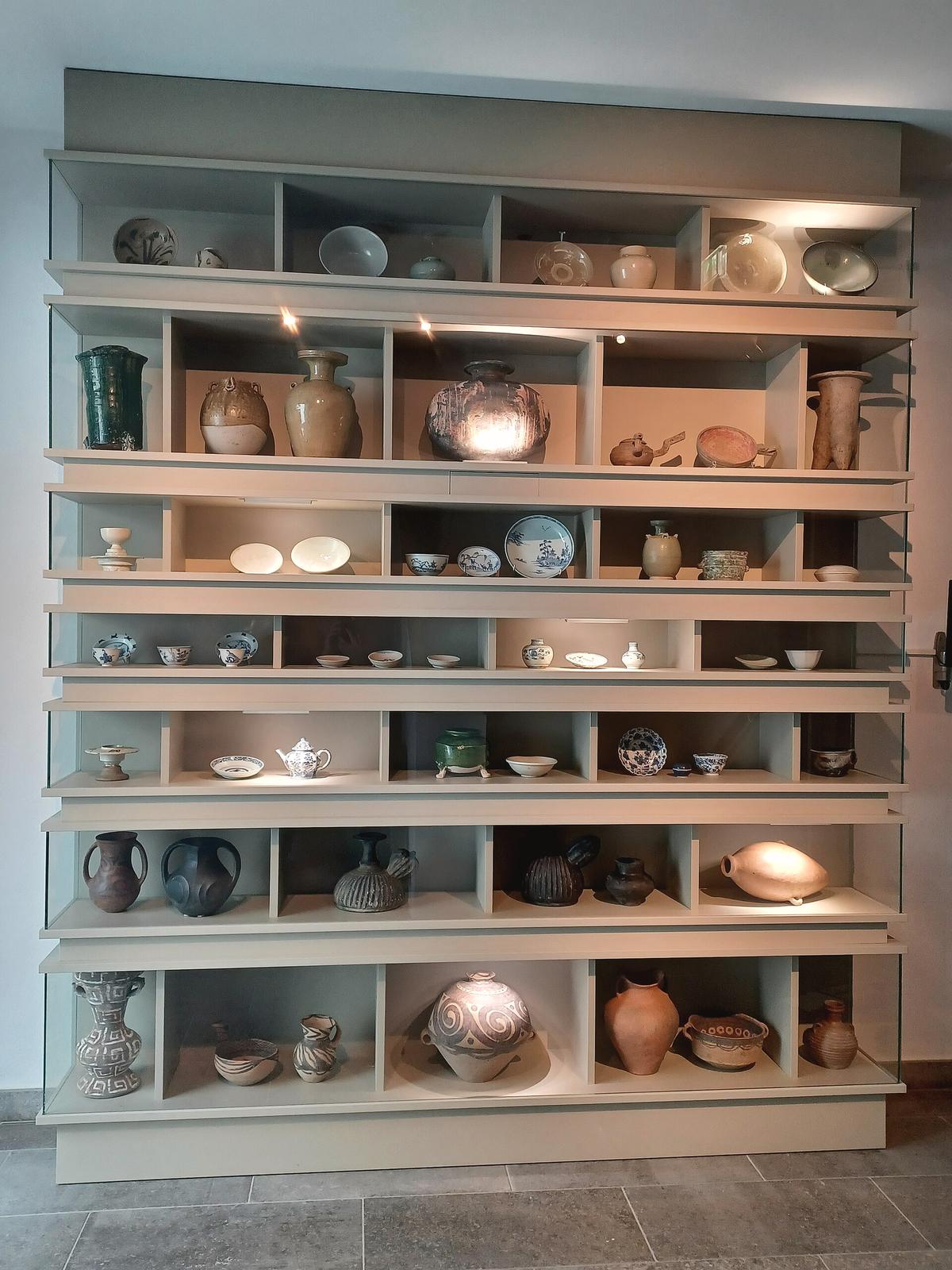 Scaffali con teiere, tazze e ceramiche